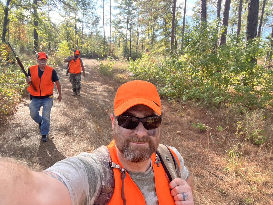 Group selfie of hunters on a trail in orange vests