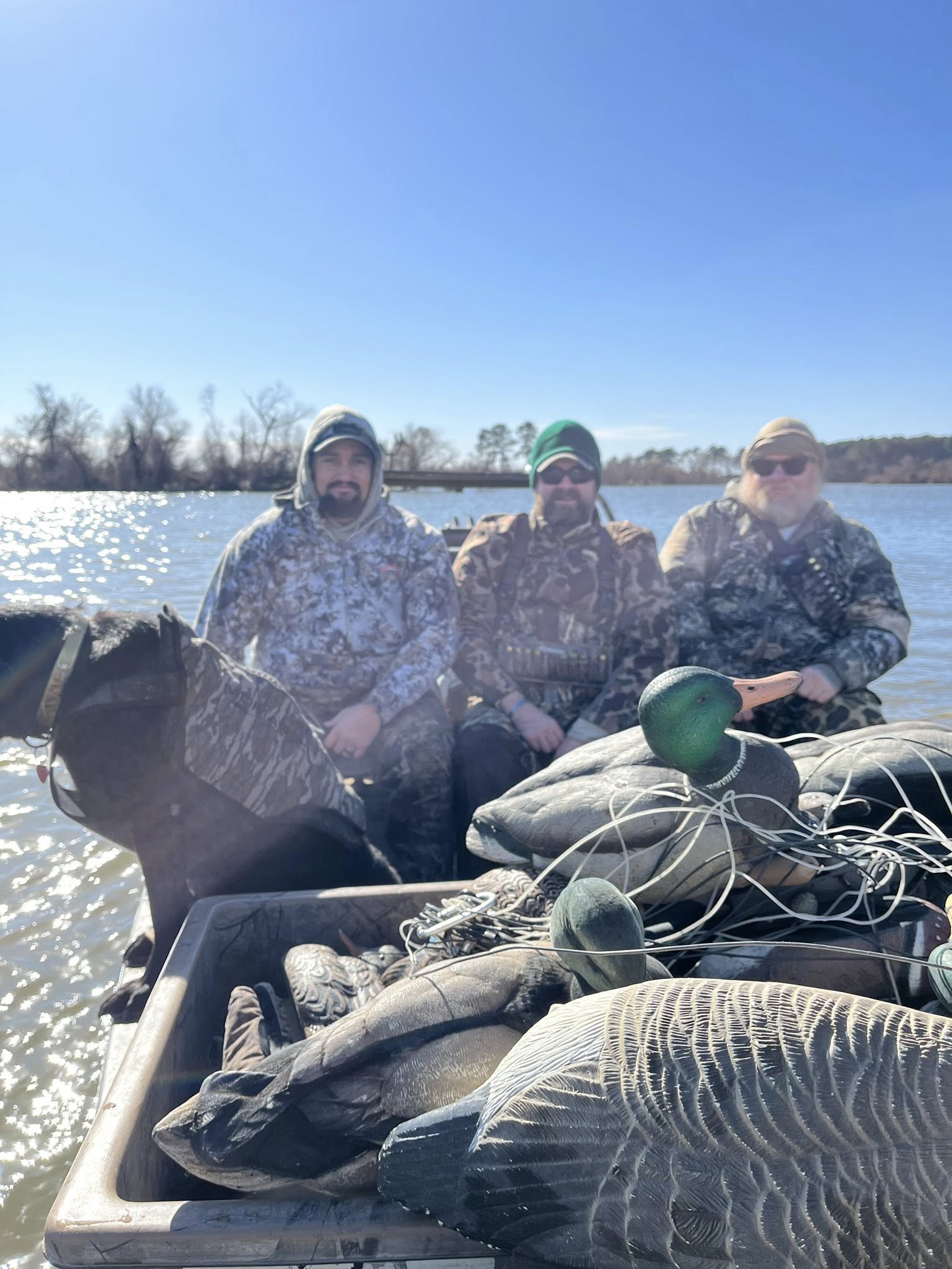 Happy hunters on a boat after a successful duck hunt with decoys